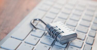 Candado de combinación sobre el teclado de un ordenador, seguridad y antivirus