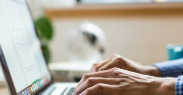 Persona tecleando en un portátil navegando por internet