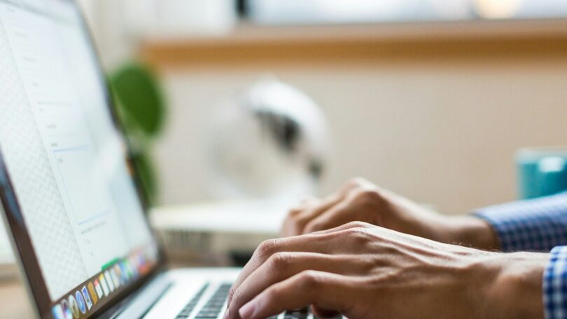 Persona tecleando en un portátil navegando por internet